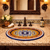 Oval talavera bathroom sink blue medallion design in Spanish Revival bathroom with arched mirror and iron sconces
