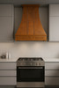 Decorative copper hood with apron grapevine detail installed in modern style kitchen