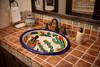 Mexican desert folk art sink displayed in a Spanish Revival bathroom with warm tile and rustic finishes