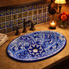 Cobalt talavera scrollwork bathroom sink featured in a restaurant washroom with warm lighting