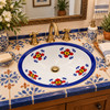 Talavera cobalt petal motif sink in Mediterranean guest bath with cream tile and brass accents