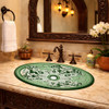 Oval green talavera mexican bathroom sink lattice in Spanish Revival bathroom with arched mirror and wrought iron fixture