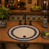 Cobalt rim Mexican bathroom sink in a rustic kitchen bar with warm handcrafted tile details.
