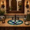 Mexican bathroom sink with green and blue motif in a bathroom with talavera tile backsplash