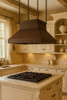 Chain suspended hammered copper island range hood in Victorian style in traditional French influanced kitchen, warm patina canopy above island with classic millwork and marble counter
