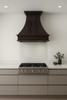 Copper range hood in modern kitchen, handcrafted metal canopy creating warm contrast with sleek cabinetry and clean surfaces