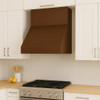 Simple under cabinet copper range hood in Scandinavian kitchen, compact hammered canopy with warm patina above light wood cabinetry and clean lines