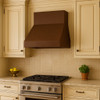 Simple under cabinet copper range hood in wall mount style kitchen, compact hammered canopy with warm patina above traditional cabinetry