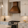 Contemporary transitional kitchen furnished with a rustic copper range hood