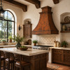 Hammered Hacienda copper range hood in a bright kitchen with timber beams, plaster walls and carved wood cabinetry