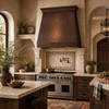 Old-World Mediterranean kitchen with hammered copper range hood, limestone surround, walnut cabinets, and arches