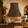 Exhaust copper kitchen hood with pyramidal shape in a hacienda kitchen with rustic tile accents