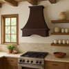 Deep concave apron copper range hood in French country kitchen with hand hammered finish