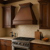 Classic copper range hood with rustic design in colonial kitchen interior, hammered copper canopy with warm patina above traditional cabinetry and stone backsplash