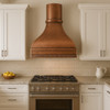 Curved bell copper range hood in a transitional kitchen with Shaker cabinetry, quartz countertops, and paneled apron