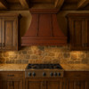 Dark patina copper kitchen range hood with riveted straps  in a rustic kitchen settings