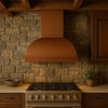 High-end rustic kitchen with a barrel copper range hood, exposed wood beams, stone surfaces, and hammered finish