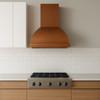 Wall-mount barrel copper range hood in a contemporary kitchen with sleek cabinetry and hand hammered finish