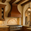 Handcrafted copper range hood with flared bell silhouette in Mediterranean influenced kitchen design