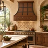 Copper range hood with grapevine apron design and straps in a Mediterranean style kitchen