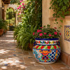 Hand-painted talavera flower planter – traditional Mexican design along a garden walkway