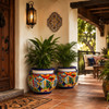 Hand-painted talavera planter with multicolor floral motifs on a covered porch