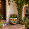Hand-painted talavera planter with multicolor floral motifs in a Mexican courtyard