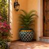 Hand painted talavera planter with green scallop pattern on a sunlit Spanish patio
