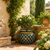 Hand painted talavera planter with green scallop pattern in a Mediterranean garden