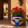 Blue floral Talavera planter filled with greenery in a welcoming hacienda entryway