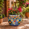 Mexican talavera flower planter displayed with greenery on a rustic outdoor terrace