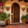 Pair of talavera lizard wall sconces with plants beside a rustic hacienda entryway