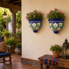 Two cobalt blue calla lily wall sconces with flowers on a warm covered porch