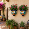 Lizard and desert sun wall sconces with flowers in a colorful Mexican courtyard