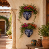 Cobalt blue talavera wall sconces with flowers displayed in a Mexican courtyard