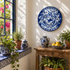 Blue floral bird decorative talavera plate traditional Mexican design showcased near a sunny window with natural daylight