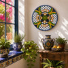 Floral lattice decorative talavera plate with green and yellow accents decorating a sunny window area with artisan accents
