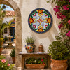 Floral lattice decorative talavera plate with black border design mounted in a Mediterranean courtyard surrounded by natural textures