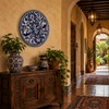 Blue bird decorative talavera plate with floral vine design showcased in a hacienda hallway with warm architectural details