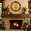 Sun face decorative talavera plate with yellow and blue design decorating a rustic fireplace mantel area