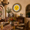 Sun face decorative talavera plate with yellow and blue design showcased above a rustic Spanish dining room table