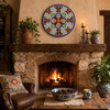 Red floral decorative talavera plate with blue lattice design featured above a rustic fireplace with handcrafted accents
