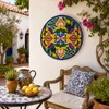 Colorful floral decorative talavera plate with cobalt blue rim showcased in a Mediterranean courtyard setting