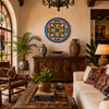 Blue medallion decorative talavera plate with green scrollwork design featured in a rustic hacienda living room interior