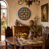Blue medallion decorative talavera plate with green scrollwork design decorating a warm Spanish dining room wall
