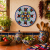 Floral lattice decorative talavera plate with cobalt blue rim displayed in a colorful Mexican kitchen with artisan pottery and rustic wood accents