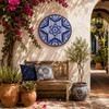 Blue white decorative talavera plate with floral lattice design decorating a Mediterranean courtyard with bright natural surroundings
