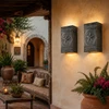 Two texas star embossed tin ranch wall sconces on a hacienda patio with warm stucco walls