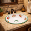 Round Mexican bathroom sink terracotta floral talavera style placed in a hacienda bathroom with stone textures and rustic decor