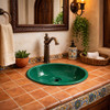 Round talavera bathroom sink solid green gloss design in a Spanish bathroom with warm tones